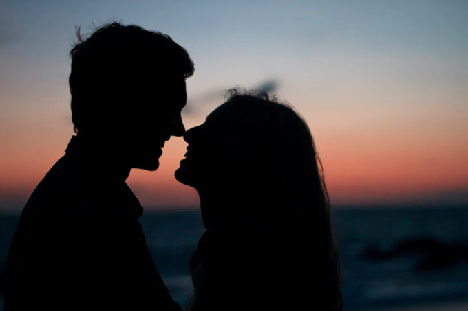 A silhouette of two people in a relationship smiling on a beach after learning how does ED affect women.